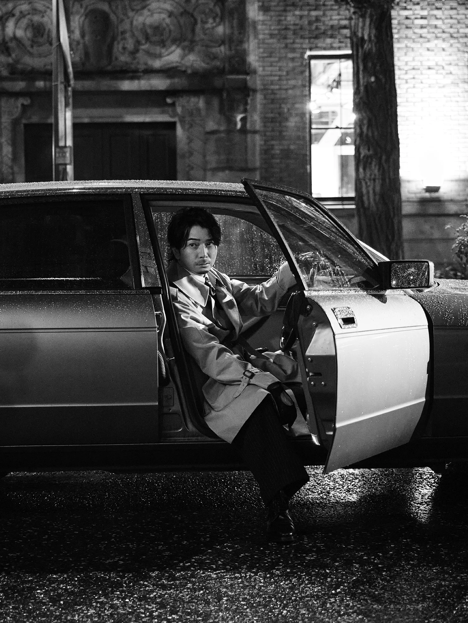 Jun Matsumoto seated in the open doorway of a car